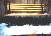 Owlcroft House: An outdoor bench in winter (with icicles).