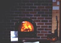 Owlcroft House: A cheery fire in the masonry heater.